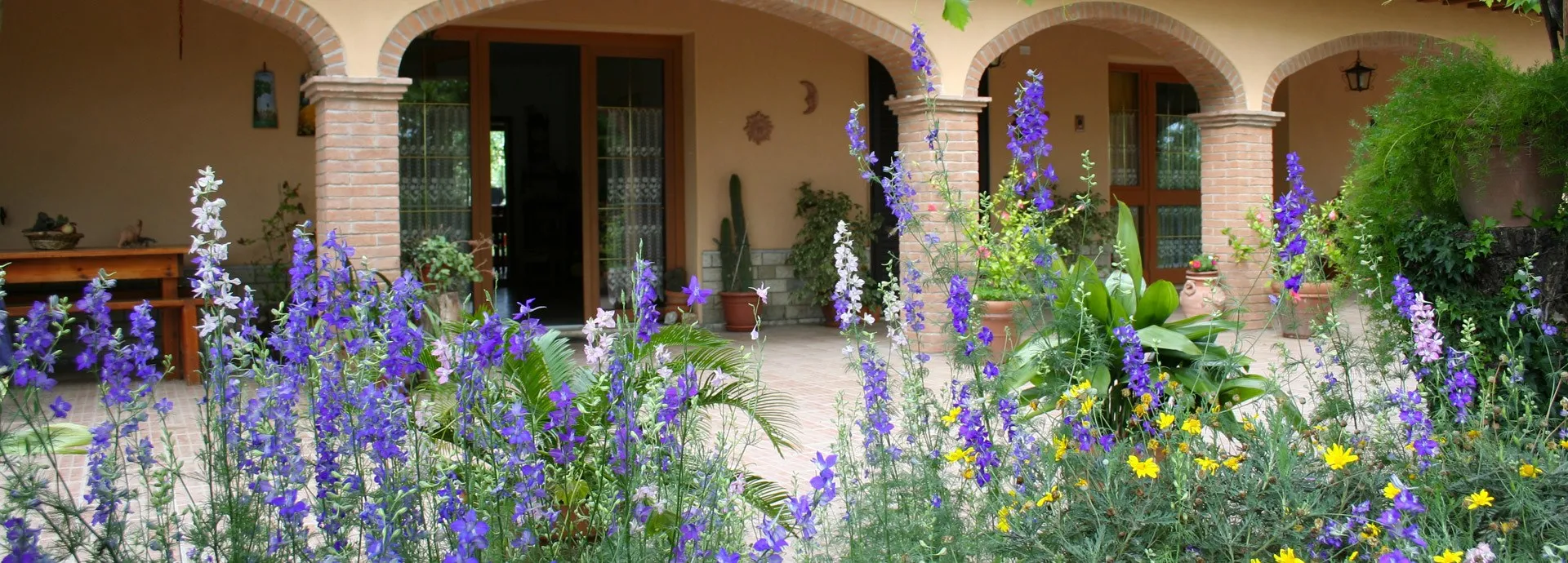 Il casale dell’Agriturismo Diciocco a Venturina Terme, con la loggia ad archi affacciata sul giardino fiorito